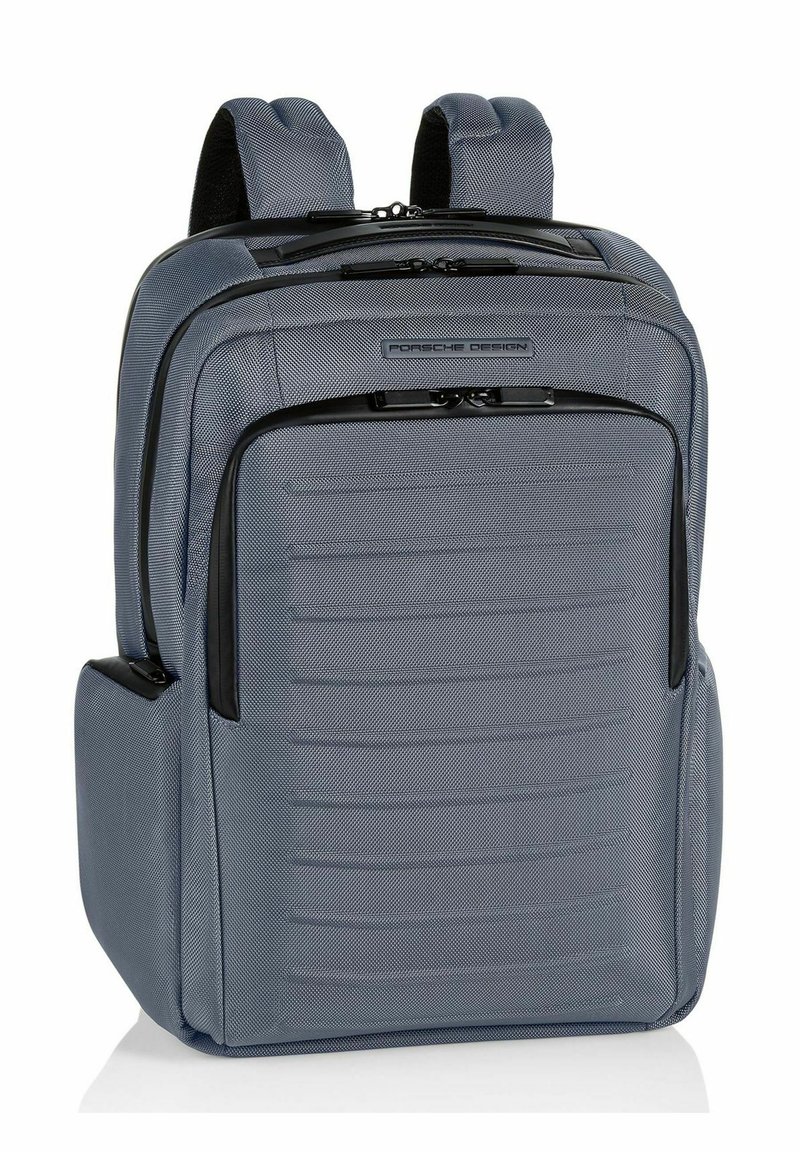 Sac à dos en tissu gris avec un dos et des bretelles rembourrées, comportant deux compartiments zippés, une poche avant et des panneaux latéraux texturés.
