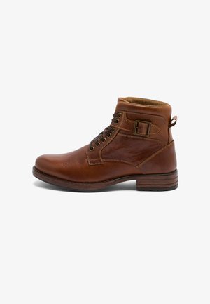 Botte d"cheville en cuir marron avec lacets, boucle latérale, col rembourré et talon empilé, vue de côté sur fond blanc.