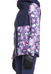 Bunte Damen-Skijacke mit einem navyfarbenen Oberteil und einem floralen Muster in Rosa und Lila. Enthält eine Kapuze und Reißverschlusstaschen.