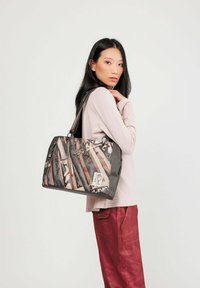 Schwarze und beige grafische Tragetasche mit geometrischen Mustern, aus Leder, mit doppelten Griffen und Hardware-Akzenten.