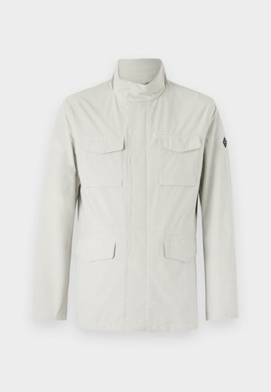 Light-colored, mid-length jacket featuring a stand collar, front zip closure, and four patch pockets. Smooth, water-resistant fabric.