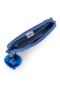 Blå lynlåse tegnebog med en tekstureret overflade, der har en blød blå pom-pom nøglering. Indeni ses to rum og et Kipling logo-tag.