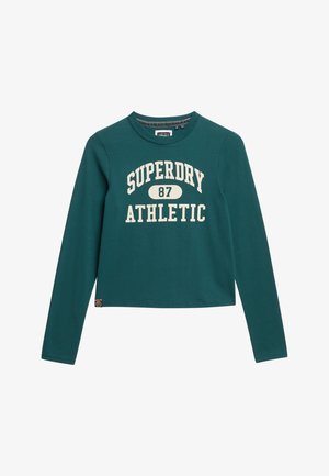 T-shirt a maniche lunghe, cropped in cotone teal con stampa bianca "SUPERDRY ATHLETIC 87". Collo a girocollo ribbed e piccolo logo etichetta sull'orlo.