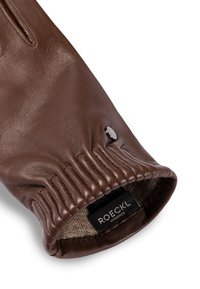Brown leather glove cuff with elastic wrist, button detail, and visible beige knitted lining showing ROECKL München brand label.