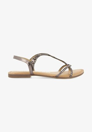 Sandalias planas en tono metálico bronce, con correas trenzadas, hebilla ajustable en el tobillo y una plantilla suave en beige con un diseño de suela mínimamente texturizado.