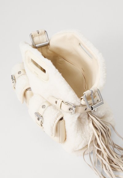 Borsa a secchiello bianca in shearling con dettagli in pelle e accessori in tono argento. L'interno è in pelle beige e presenta due tasche esterne e un dettaglio con frange.