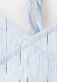 Tissu bleu clair avec fines rayures verticales noires et détail de couture croisée près des bretelles en tissu torsadé.