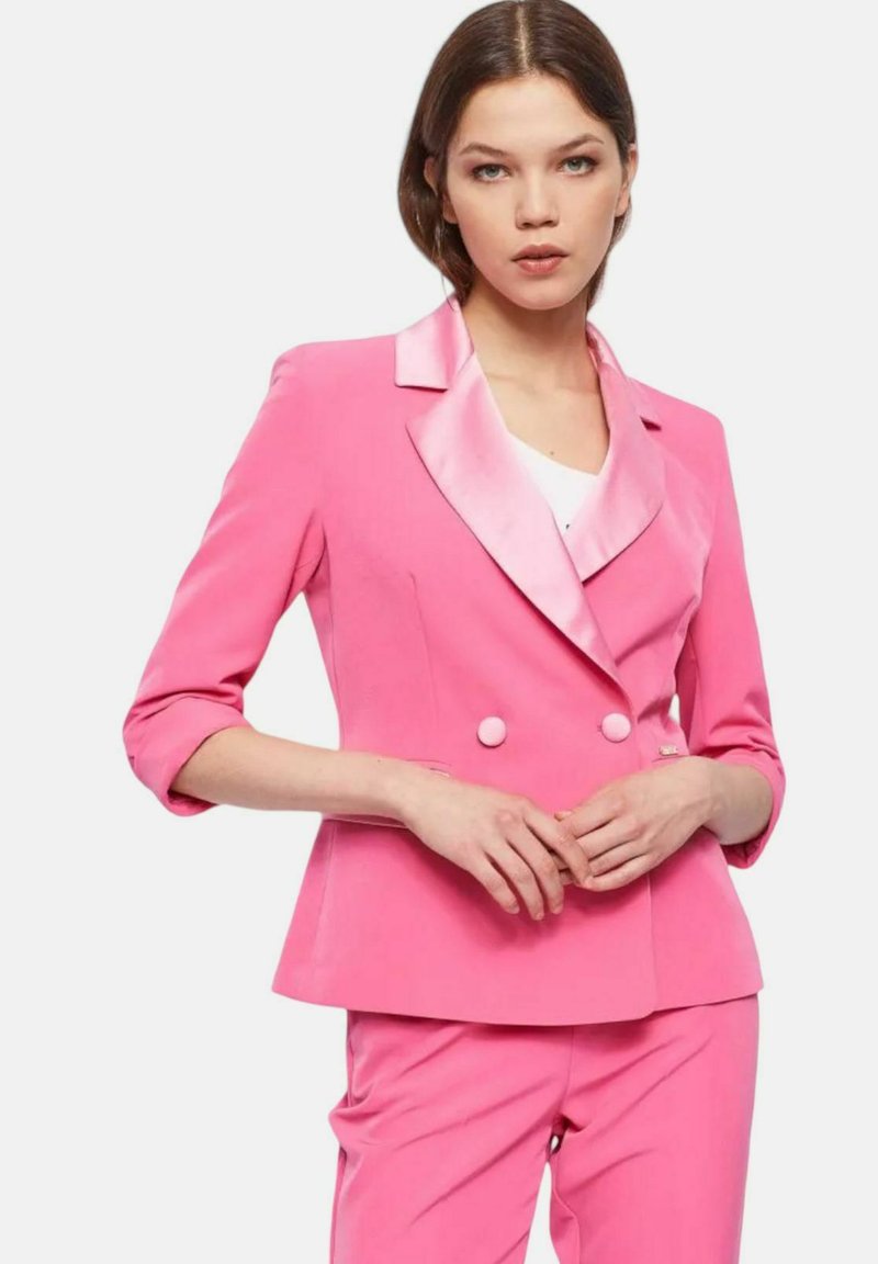 Blazer rosa a doppio petto con revers in satin e maniche a tre quarti, dotato di bottoni rotondi e vestibilità sartoriale.