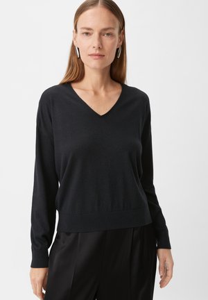 Czarny sweter w serek z miękkiej dzianiny, z długimi rękawami i dopasowanym wykończeniem. Prosty design, idealny do noszenia w warstwach.