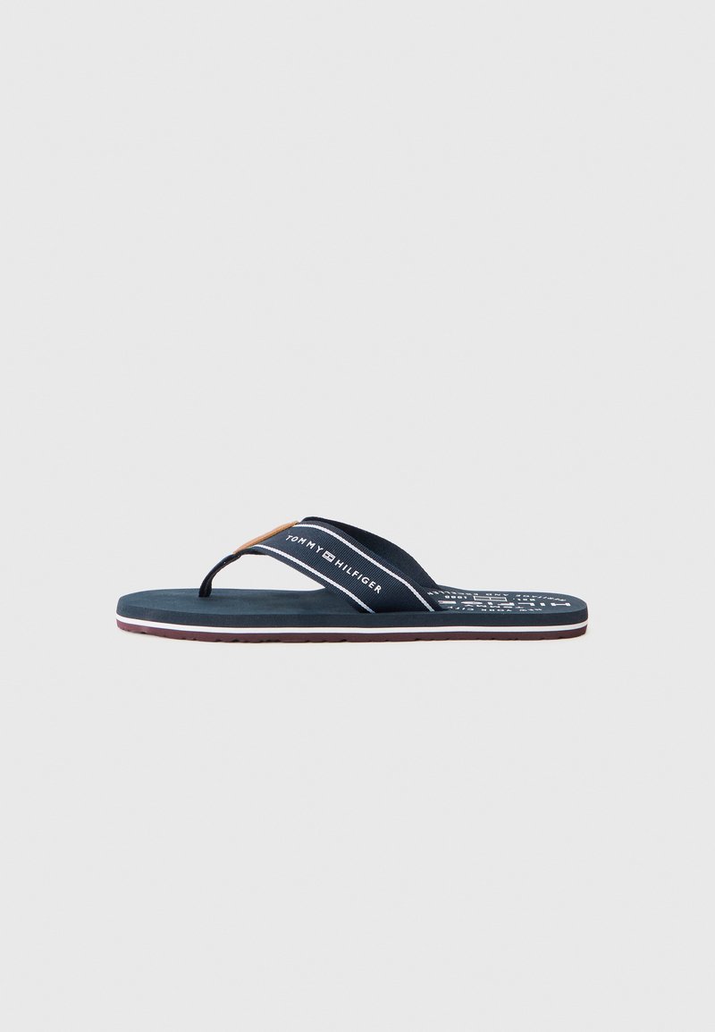 Sandale flip-flop marine cu talpă din cauciuc, curele din material textil și detalii imprimate cu logo. Design subțire cu thong, cu accente roșii și albe.
