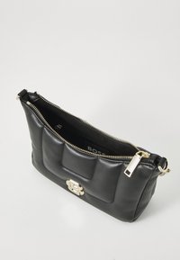 Černá kožená kabelka s prošívaným designem, zlatým zipem a značkovým detailem. Má jednu přihrádku a obdélníkový tvar.