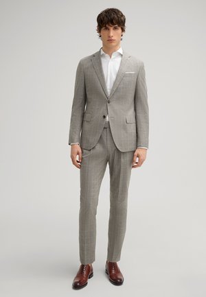 Gray plaid suit with a tailored fit, featuring a two-button jacket and flat-front trousers. Paired with a crisp white shirt and brown shoes.