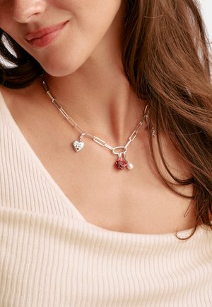 Silberkettenglied-Halskette mit einem Herzanhänger, einem roten Rosenanhänger und einer Perle, mit strukturierter Oberfläche und einem zentralen Verschluss.