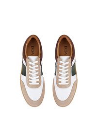 Sneaker mit einem Obermaterial aus weißem Leder, einem Kragen aus braunem Leder, beigen Wildlederakzenten, grüner Seitenmarkierung und weißen Schnürsenkeln auf einer Gummisohle.
