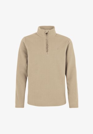 Junge trägt beigen Fleecepullover, dunkelblaue Schneehose, schwarze Stiefel und dunkelblaue Strickmütze und steht vor einem schlichten hellen Hintergrund.