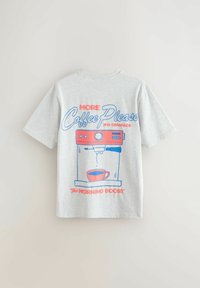 Lysegrå t-shirt med grafik af en rød og blå kaffemaskine, kop og teksten "Mere kaffe tak fra kl. 7 Morgenboost."