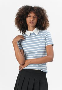 Polo a maniche corte blu e bianche a righe con colletto bianco, dotato di un piccolo logo sul petto e di un tessuto morbido e testurizzato.