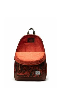 Sac à dos rouge avec des motifs tribaux noirs, doté d'un intérieur orange et d'un rabat supérieur. Fabriqué en tissu durable avec des accents marron.