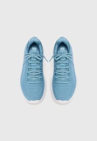 Zapatillas deportivas de color azul claro con un upper texturizado, cordones planos y suelas blancas. El diseño presenta líneas diagonales en los laterales.