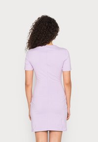 Kort lila klänning med korta ärmar, figursydd design och rund halsringning. Slät textur, minimal detaljering och en stilren silhuett.