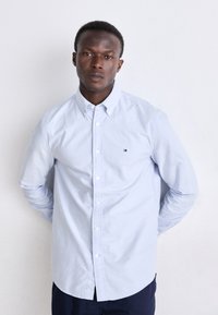 Lichtblauw button-up shirt van katoen, met een puntige kraag, lange mouwen en een klein logo op de borst.