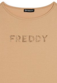 T-shirt beige con scollatura rotonda, caratterizzato dalla parola "FREDDY" scritta con piccoli chiodini metallici sul petto.