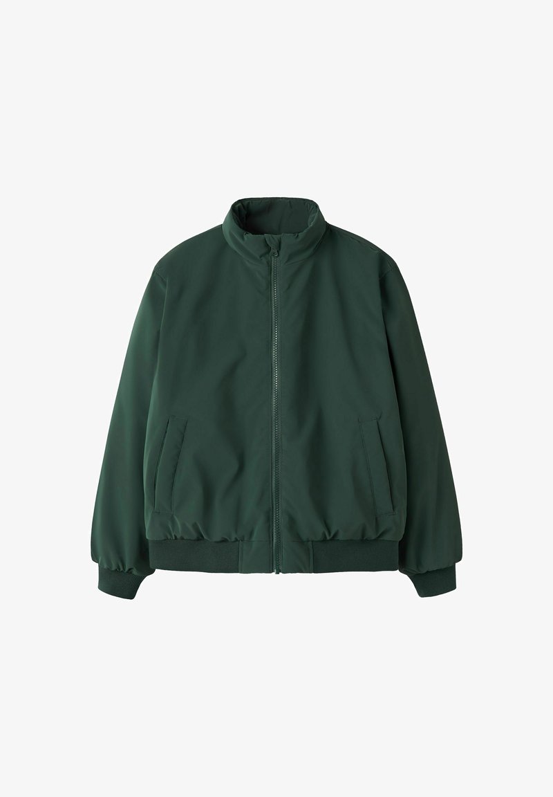Veste zippée vert foncé avec col montant, poignets et bas côtelés, et deux poches latérales sur fond blanc.