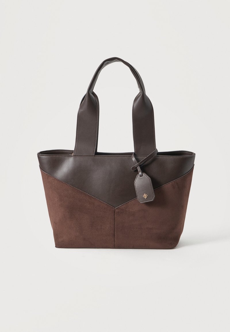 Sac cabas marron avec des anses en cuir marron foncé et une partie supérieure, avec une petite étiquette en cuir attachée.
