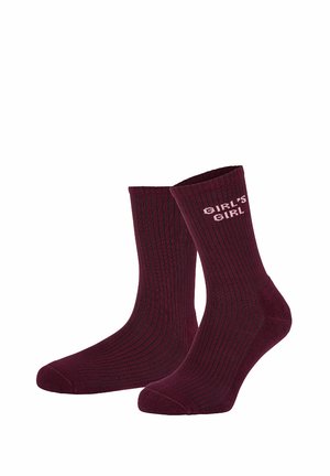 Tumman burgundinpunaiset ribbineulotut sukat, joissa toisessa sukassa yläosassa ulkosyrjällä vaaleanpunainen teksti "GIRL'S GIRL".