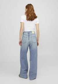 Ljusblå högmidjade vida jeans med smalare botten och två bakfickor, med en liten etikett vid midjan.