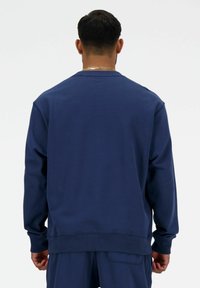 Sudadera azul marino hecha de una tela suave, con cuello redondo, mangas largas y puños y dobladillo de canalé para un ajuste cómodo.