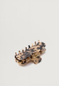 Plačiamą šukuoseną laikančiu plaukų spaustuku, pagamintu iš plastiko, su kreivais kraštais, daugybe sukimų ir permatomu vyzdžiu.