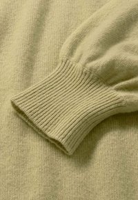 Hellgrüner Strickpullover mit einem fest gerippten Bündchen und weichem, texturiertem Stoff. Das Design umfasst leicht puffige Ärmel und einheitliche Nähte.