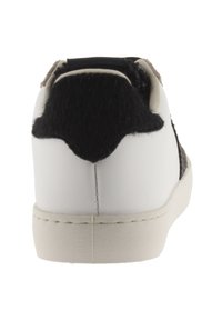 Sneaker bianco con pannello posteriore texturizzato nero e marrone e lati lisci, dotato di suola in gomma piatta e dettagli cuciti.
