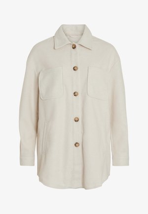 Veste en laine beige, avec un devant boutonné, deux poches poitrine et une coupe décontractée. Elle présente des boutons bruns contrastants et un col classique.