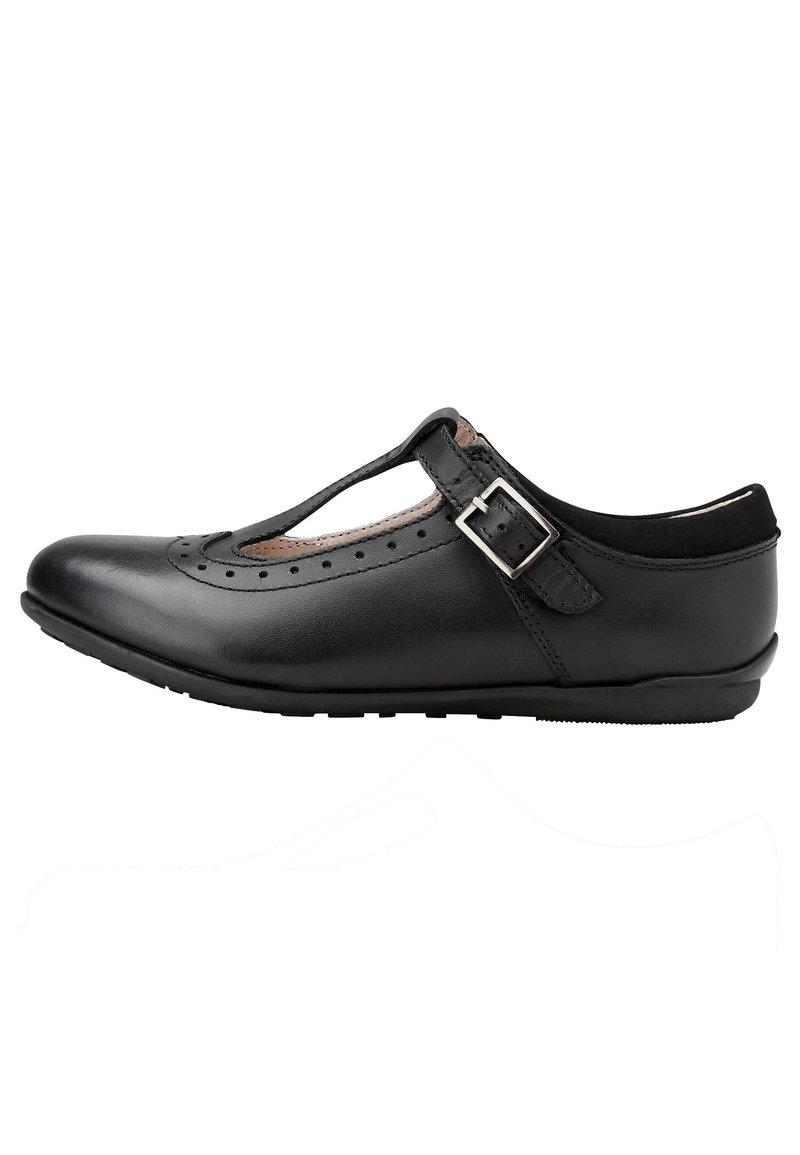 Pantof cu piele neagră, cu un design decupat, curea în formă de T și cataramă argintie ajustabilă. Prezintă perforații brogue pe vârful și marginea pantofului. Talpă plată.