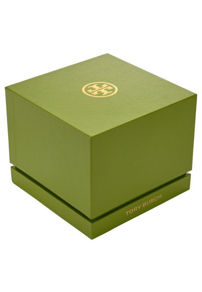 Boîte rectangulaire verte texturée avec un logo Tory Burch doré sur le dessus et le nom de la marque imprimé en doré sur le côté. Forme carrée, sans fermetures visibles.