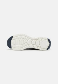 Shoe sole with a patterned white rubber base, navy accent on the heel, and textured traction for grip. Flat and minimal design.