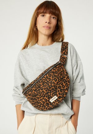 Sac bandoulière imprimé léopard de forme arrondie, fabriqué en tissu, avec une fermeture éclair sur le dessus et une sangle ajustable.