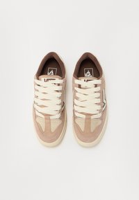 Adidași cu un amestec de suede bej deschis și maro deschis, având șireturi crem, un guler căptușit și accente laterale subtile în maro închis.