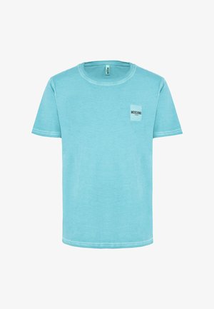 T-shirt in cotone turchese con scollo rotondo, maniche corte e una piccola etichetta bianca sul petto che mostra il nome del marchio "Moschino."