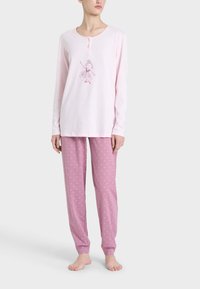 Maglietta da pigiama rosa a maniche lunghe con scollo rotondo e grafica di ballerina, abbinata a pantaloni rosa a fantasia con piccoli cuori bianchi.