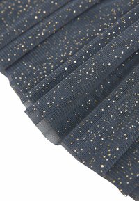 Tissu texturé bleu marine avec des éclats métalliques dorés, présentant des plis et un revêtement semi-transparent pour plus de dimension et de style.