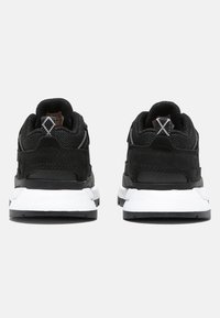 Black athletic shoes featuring a mesh and leather upper, padded collar, white midsole, and contrasting black outsole. Dual heel tabs included.