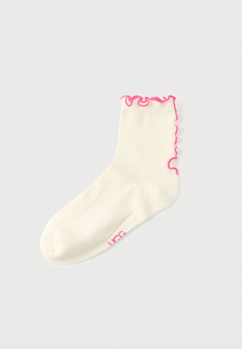Βαμβακερό αστραγάλιο καλτσάκι σε εκρού χρώμα με ροζ βολάν στην κορυφή και ροζ λογότυπο στο πλάι. Μαλακή υφή και ελαστική εφαρμογή.