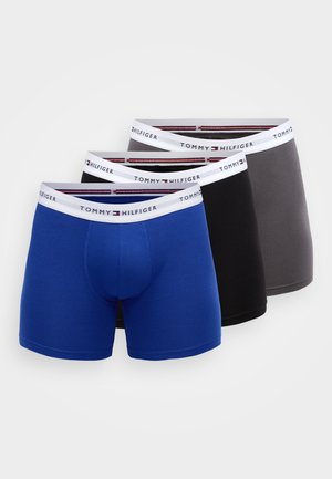 Kolm paari meeste bokserpükse: üks sinine, üks must ja üks hall. Igaühel on valge vöö, millel on "TOMMY HILFIGER" logo.