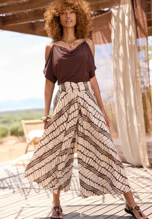 Brown fabric top with draped neckline, paired with high-waisted palazzo pants featuring an alternating cream and brown wavy pattern.