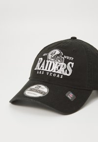 Juodas beisbolo kepurė su reguliuojamu dirželiu. Puošia siuvinėjamas "Raiders" logotipas ir Las Vegas tekstas baltos spalvos. Pridedama New Era lipdukas.