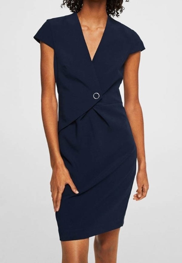 Robe bleu marine avec un décolleté en V profond, des manches courtes, des plis latéraux et un détail circulaire à la taille, fabriquée en tissu lisse.