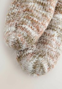 Close-up of brown, beige, and white fuzzy knit socks showing detailed texture and pattern on a light background.